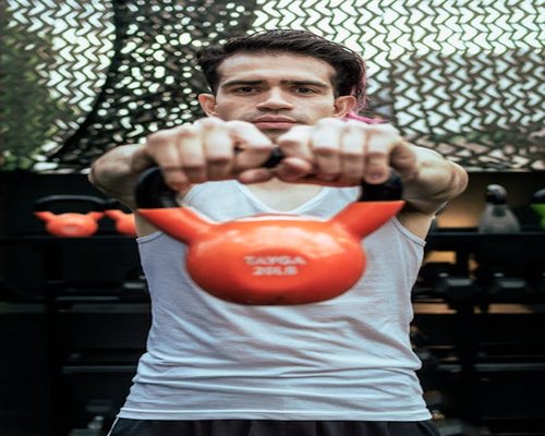 Portrait of coach Diego holding a kettlebell